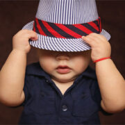 baby boy with hat pulled over eyes.
